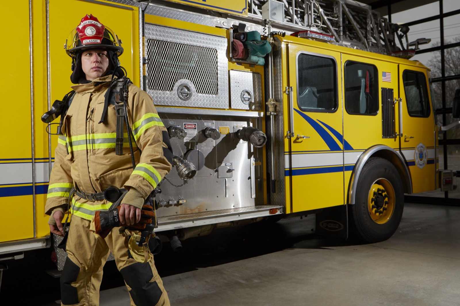 Firefighter posed in LION V-Force turnout uniform at a fire station